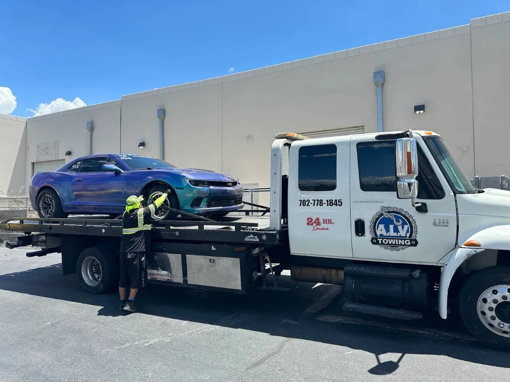 A.L.V. Towing operator securing sports car on flatbed