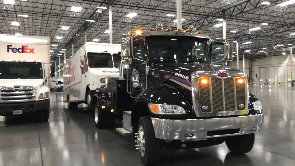 A.L.V. Towing black Peterbilt heavy tow truck with commercial vehicle